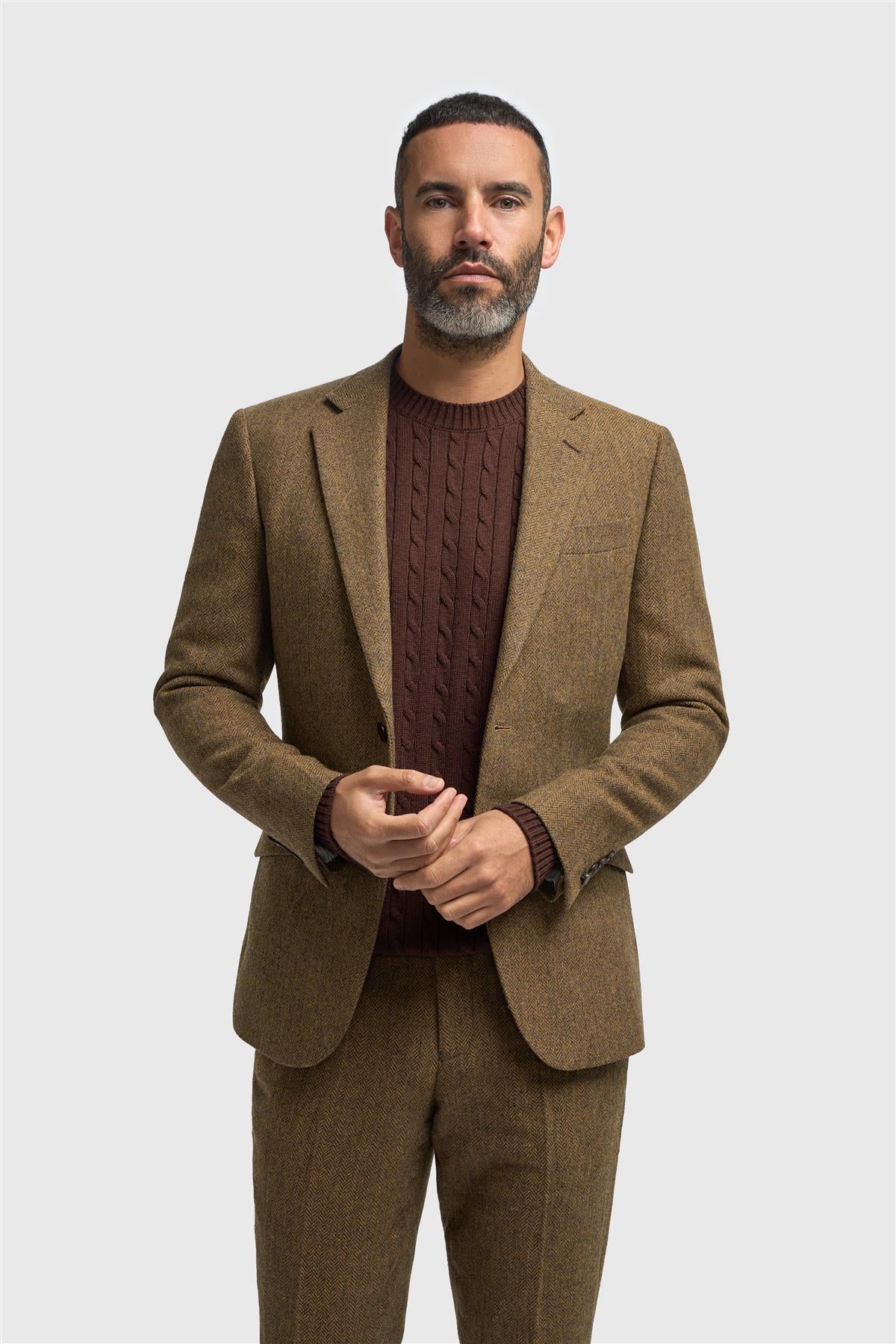 Man wearing a brown suit and maroon sweater on a white background